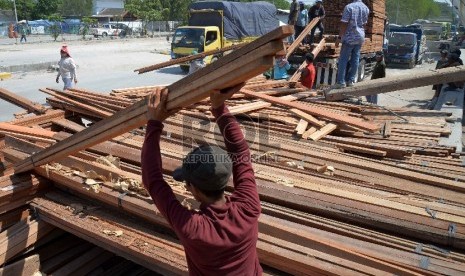 Proyeksi Ekspor Kayu dan Produk Kayu: Pekerja mengangkut kayu di Pelabuhan Sunda Kelapa, Jakarta Utara, Kamis (12/2). 