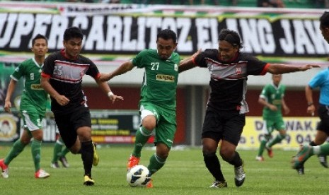 PSS Sleman, Fajar Listyantoro (tengah) berebut bola dengan dua pesepakbola Persis Solo, Diva Tarkas (kiri) dan Haryadi Putul (kanan)