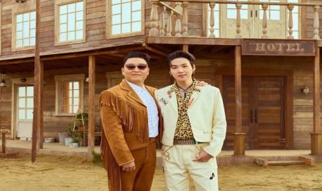 PSY (kiri) dan Suga BTS (kanan) berfoto saat syuting video musik That That. Suga dan PSY buka-bukaan soal jebakan kepada Suga sehingga dia terlibat lebih banyak di lagu That That.