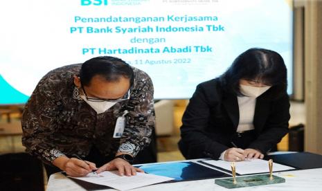 PT Hartadinata Abadi Tbk (HRTA) Sandra Sunanto (kanan) menandatangani kesepakatan kerja sama transaksi pembelian emas batangan dengan PT Bank Syariah Indonesia Tbk (BSI) di Jakarta,  Kamis (11/8/2022).