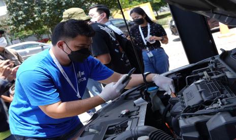 Petugas sedang memeriksa kondisi mesin kendaraan yang hendak dijual di OLX Autos GIIAS 