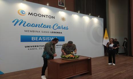 Public Relations & Communications Manager Moonton Indonesia Azwin Nugraha (kiri) dan Direktur Kemahasiswaan UGM, Sindung Tjahyadi, memotong tumpeng nasi pada acara penandatanganan MoU antara Universitas Gadjah Mada (UGM) dengan Moonton Indonesia melalui program Moonton Cares Membina Sang Legenda di Auditorium MM UGM, Kamis (22/12/2022).