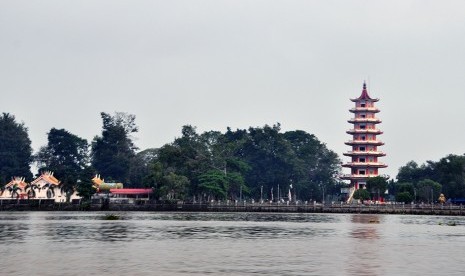 Pulau Kemaro yang terletak di tengah Sungai Musi dengan Pagoda dan wihara tempat beribadah umat Tridharma di bagian tengah.