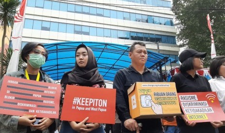 Puluhan orang dari koalisi masyarakat sipil sedang melakukan aksi di depan kantor Kominfo, Jalan Merdeka Barat, Jakarta Pusat, Jumat (23/8). Mereka menuntut agar pemerintah segera menghentikan pemblokiran internet di Papua dan Papua Barat.