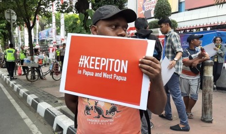 Puluhan orang dari koalisi masyarakat sipil sedang melakukan aksi di depan kantor Kominfo, Jalan Merdeka Barat, Jakarta Pusat, Jumat (23/8). Mereka menuntut agar pemerintah segera menghentikan pemblokiran internet di Papua dan Papua Barat.