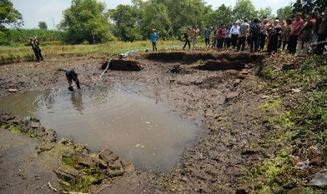 Puluhan pemerhati budaya dari Jaringan Pelestarian Pusaka Indonesia (BPPI) saat mengikuti rangkaian peringatan Hari Pusaka Dunia 2013 kunjungan ke situs kolam kuno peninggalan Majapahit di Desa Nglinguk, Trowulan, Mojokerto,