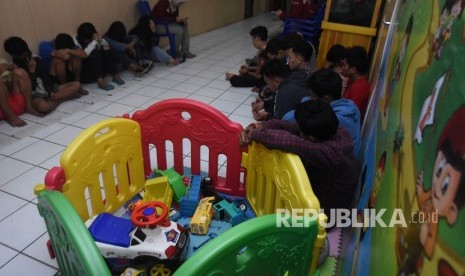 Puluhan pemuda anggota geng motor Jembatan Mampang (Jepang) menunggu pemeriksaan urine seusai penangkapan di Polresta Depok, Jawa Barat, Senin (25/12). 