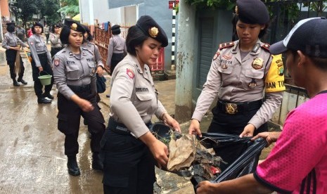 Puluhan  Polisi Wanita (Polwan) turut serta  membantu warga Rw 04, Cipinang Melayu, Makasar, Jakarta Timur membersihkan rumah dan lingkungannya usai banjir yang merendam wilayah tersebut. Permukiman yang berada di bantaran Kali Sunter itu terendam banjir h