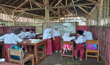 Puluhan siswa di SDN Sinagar, Kampung Bungursari, Desa Sindangasih, Kecamatan Cikatomas, melakukan KBM di ruang kelas darurat menyerupai gubuk, Selasa (11/10/2022). Ruang kelas darurat yang terbuat dari bambu dengan dilapisi terpal dan beratapkan genting, itu dibangun secara swadaya oleh guru dan warga sekitar, lantaran kondisi ruang kelas di sekolah sudah tak layak digunakan.