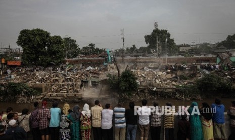 Puluhan warga menyaksikan penggusuran di pemukiman yang terkena proyek normalisasi Sungai Ciliwung, Bukit Duri, Jakarta, Rabu (28/9). 