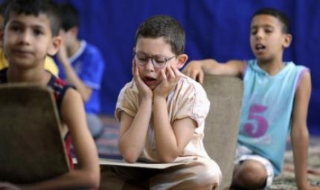 Pupils read and learn the Koran during the holy fasting month of Ramadan, at a mosque in Kheraisia, east of Algiers July 8, 2014. 