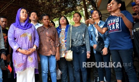 Puteri mantan presiden Abdurrahman Wahid (Gus Dur) Yenny Wahid (kiri) bersama sejumlah mahasiswa asal Papua menyanyikan lagu Indonesia Raya saat ziarah ke makam Gus Dur di Pesantren Tebuireng, Jombang, Jawa Timur, Rabu (21/8/2019). 