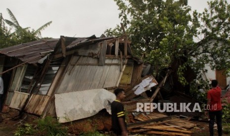  Puting Beliung Di Kupang. Warga berjalan di samping rumah yang roboh akibat diterjang angin puting beliung di Kota Kupang, NTT, Kamis (28/2/2019) sore.