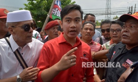 Putra sulung Presiden Joko Widodo, Gibran Rakabuming Raka (tengah) berjalan menuju Kantor DPD PDI Perjuangan Jawa Tengah untuk mengembalikan formulir pendaftaran pencalonan sebagai Wali Kota Surakarta di Semarang, Jawa Tengah, Kamis (12/12/2019).