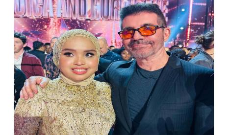 Putri Ariani (kiri) berfoto bersama Simon Cowell (kanan) seusai pengumuman voting final AGT.