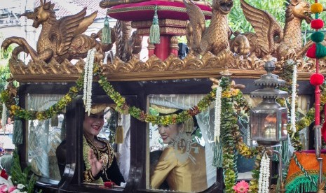 Putri Presiden Joko Widodo, Kahiyang Ayu, melambaikan tangan saat naik kereta kencana menuju acara ijab dan resepsi pernikahan di Graha Saba Buana, Solo, Jawa Tengah, Rabu (8/11).