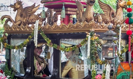 Putri Presiden Joko Widodo, Kahiyang Ayu, melambaikan tangan saat naik kereta kencana menuju acara ijab dan resepsi pernikahan di Graha Saba Buana, Solo, Jawa Tengah, Rabu (8/11).