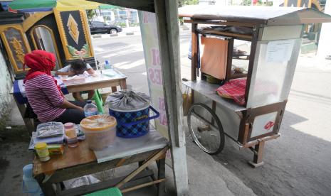 Quinina siswi kelas dua SDN 2 Sorogenen belajar di warung ibunya di kawasan Purwomartani, Sleman, Yogyakarta.