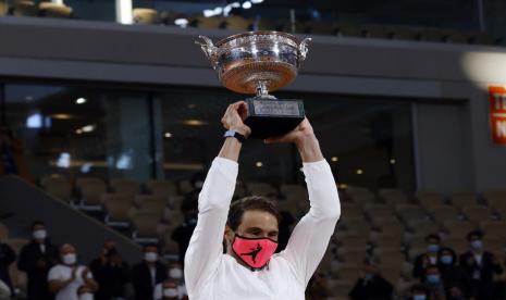 Rafael Nadal mengangkat la Coupe des Mousquetaires, trofi yang diberikan pada juara tunggal putra French Open di lapangan utama Philippe Chatrier, Roland Garros, Paris, Ahad (11/10)