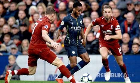 Raheem Sterling (tengah) diadang Jordan Henderson (kanan) dan James Milner (kiri) pada pertandingan Liga Primer Inggris antara Liverpool melawan Manchester City di Stadion Anfield, Ahad (7/10) waktu setempat.