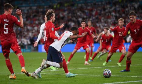 Winger Inggris Raheem Sterling (tengah) dilanggar di kotak penalti saat semifinal UEFA EURO 2020 melawan Denmark.