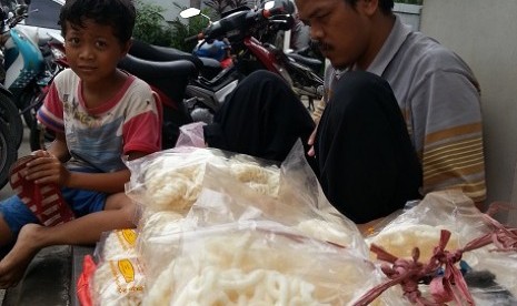 Rahmat (11 tahun) membantu ayahnya, Ade Djunaedi (35) yang tunanetra menjual kerupuk ikan. Mereka menjual kerupuk SPBU Pondok Pinang, Jakarta Selatan.