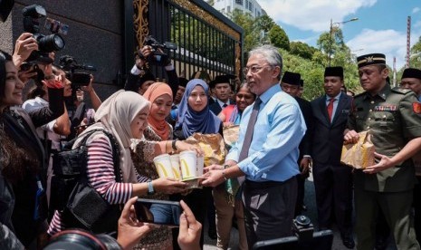 Raja Malaysia Abdullah mendisteibusikan makanan cepat saji kepada pers Malaysia, Selasa (25/2).