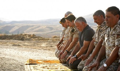 File - Raja Yordania Abdullah II (ketiga dari kanan) shalat saat mengunjungi wilayah perbatasan dengan Israel, Baqura, bersama Putra Mahkota Pangeran Hussein (keempat dari kanan) dan petugas militer. 