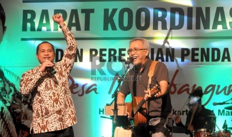 Rakornas Kementerian Desa Menteri Desa, Pembangunan Daerah Tertinggal dan Transmigrasi (PDTT) Marwan Jafar bersama Musisi, Iwan Fals bernyanyi saat pembukaan Rapat Koordinasi Nasional Kementerian Desa PDTT di Jakarta, Selasa (31/3). 