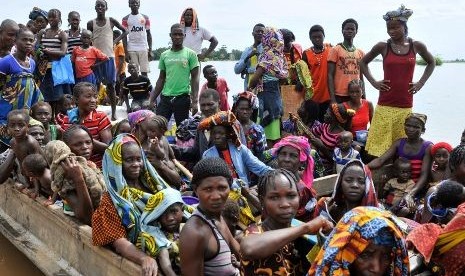 Rakyat Nigeria menggunakan perahu mengungsi dari tempat tinggalnya akibat banjir parah yang melanda negara itu sejak Selasa (2/10/2012) kemarin.