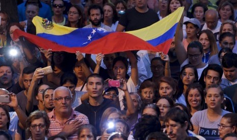 Rakyat venezuela mendengarkan pidato pemimpin oposisi Juan Guaido yang memproklamirkan diri sebagai presiden di Caracas, Venezuela, Kamis (28/3).