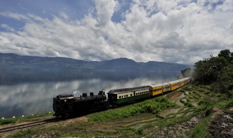 Rangkaian kereta yang ditarik lokomotif tua Mak Itam melaju di Sumatra Barat.