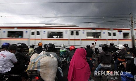 Rangkaian KRL Commuterline  melintas dikawasan Kota Bogor, Jawa Barat, Sabtu (30/12). PT Kereta Commuter Indonesia (PT KCI) sebagai operator KRL Commuterline menambah perjalanan KRL untuk warga selama pergantian tahun dengan 23 perjalanan KRL tambahan disediakan bagi pengguna jasa KRL hingga pukul 02.00 WIB. 