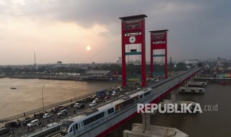 Rangkaian Light Rail Transit (LRT) Palembang melintas di atas Sungai Musi, Palembang, Sumatra Selatan, Senin (23/7).