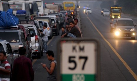  Rasa jenuh menyelimuti para pemudik akibat kendaraan mereka terjebak kemacetan panjang dan berhenti total di KM 57, Cikarang, Jawa Barat, Jumat (17/8).   (Prayogi)