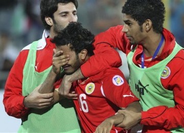 Rashed Al Hooti (tengah), bek timnas Bahrain, tak kuasa menangis setelah diganjar kartu merah ketika pertandingan baru berlangsung 47 detik.