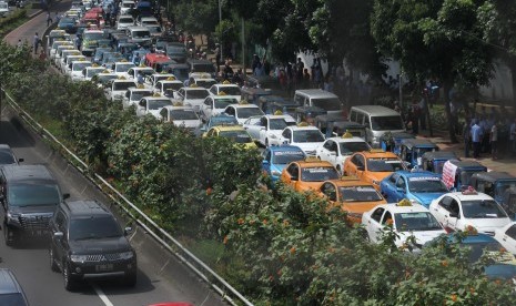 Ratusan angkutan umum jenis taksi terparkir diruas jalan Semanggi saat melakukan unjuk rasa di kawasan Senayan, Jakarta, Selasa (22/3).