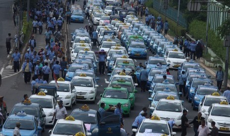 Ratusan angkutan umum jenis taksi terparkir diruas jalan Semanggi saat melakukan unjuk rasa di kawasan Senayan, Jakarta, Selasa (22/3).