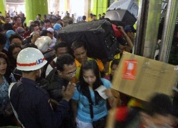 Ratusan calon penumpang kereta api mengantre saat memasuki Stasiun Gambir di Jakarta, Jumat (26/8).