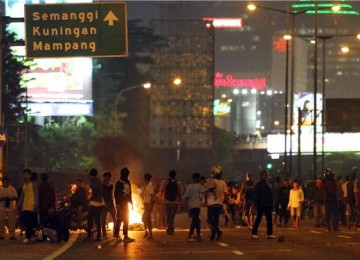 Ratusan demonstran menutup jalan saat bentrok dengan petugas kepolisian usai aksi unjuk rasa menolak kenaikan harga BBM di depan gedung DPR/MPR, Senayan, Jakarta, Jumat malam (30/3). 