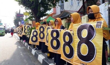 Ratusan kader PKS yang mayoritas perempuan berderet sepanjang dua kilometer di Jalan RE Martadinata Kota Sukabumi dengan membawa spanduk bertuliskan nomor 8 sebagai sosialisasi nomor urut partai Ahad (18/11).