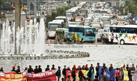   Ratusan kendaraan terjebak kemacetan akibat aksi ribuan buruh yang melakukan long march dari Bundaran Hotel Indonesia menuju Istana Negara di Jalan MH Thamrin, Jakarta Pusat, Rabu (6/2). (Republika/Adhi Wicaksono)