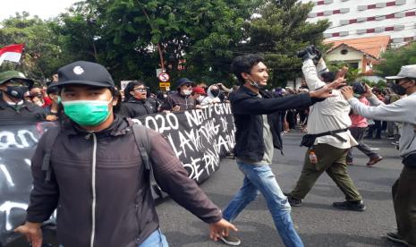 Ratusan massa aksi menggelar aksi unjuk rasa menolak disahkannya Undang-Undang Cipta Kerja atau Omnibus Law di depan Gedung Negara Grahadi, Surabaya, Kamis (8/10).