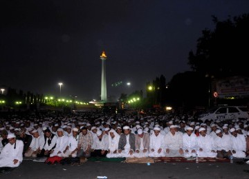 Ratusan Massa Forum Umat Islam (FUI) melaksanakan salat Maghrib saat berunjuk rasa di depan Istana Merdeka, Jakarta, Jumat (30/3). (Republika/Prayogi)