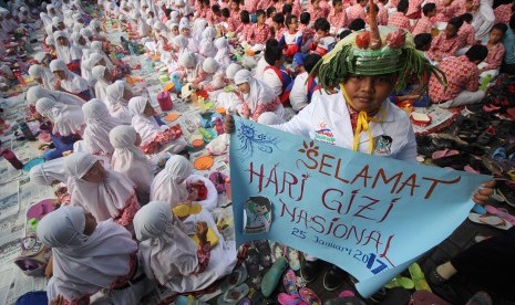 Ratusan murid SD Muhammadiyah 15 Surabaya mengikuti sarapan bersama pada acara Bancakan Hari Gizi Nasional di halaman sekolah mereka di Surabaya, Jawa Timur, Rabu (25/1).