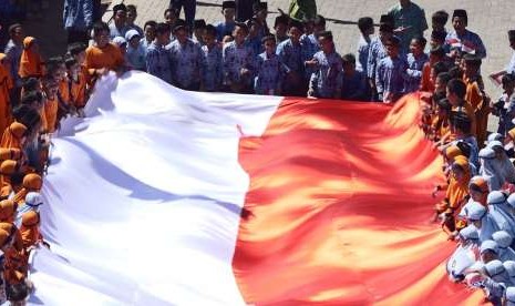 Ratusan murid SD Muhammadiyah Plus Kota Salatiga membentangkan bendera Merah Putih raksasa, di halaman sekolah mereka, Kamis (16/8). Bendera berukuran 25 x 5 meter ini sebelumnya dijahit oleh 150 murid SD Muhammadiyah Plus ini. 