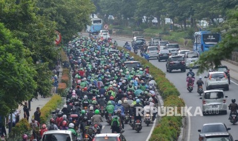  Ratusan pengemudi Gojek melintasi Jalan Rasuna Said saat konvoi menuju Monas, Jakarta Pusat, Selasa (22/3).