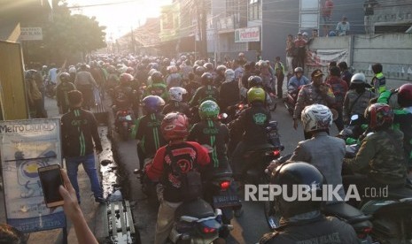 Ratusan pengemudi ojek online melakukan aksi solidaritas di jalan raya Bojongsoang, Kabupaten Bandung, Jumat (27/7). Mereka mendatangi jalan Cikoneng, tempat kejadian terjadinya pemukulan oleh oknum ojek pangkalan kepada ojek online.