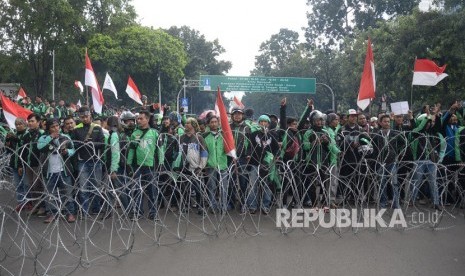  Ratusan pengemudi ojek online (Ojol) melakukan aksi unjuk rasa di depan Istana Merdeka, Jakarta, Selasa (27/3).