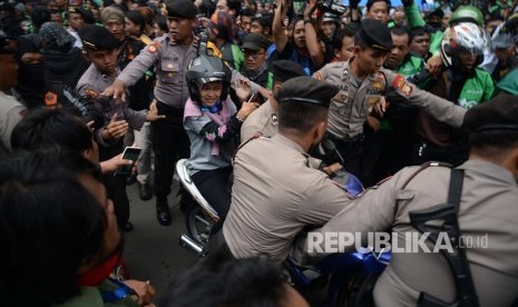  Ratusan pengemudi ojek online (Ojol) melakukan aksi unjuk rasa di depan Istana Merdeka, Jakarta, Selasa (27/3).